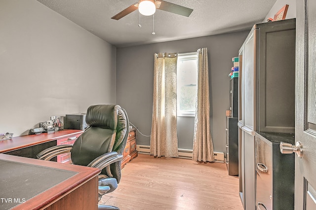office space featuring a textured ceiling, a baseboard radiator, a ceiling fan, and light wood finished floors