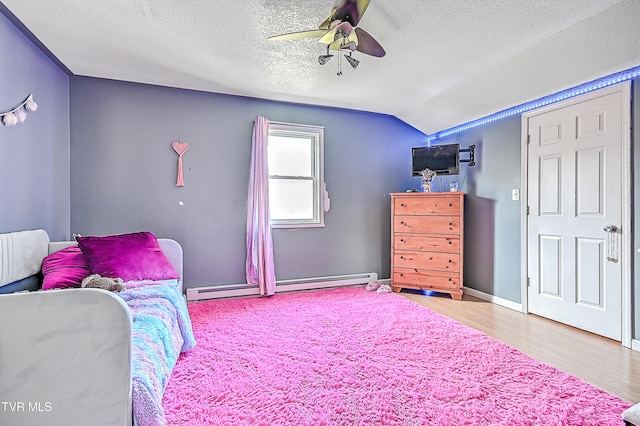 bedroom with vaulted ceiling, a textured ceiling, ceiling fan, a baseboard radiator, and wood finished floors
