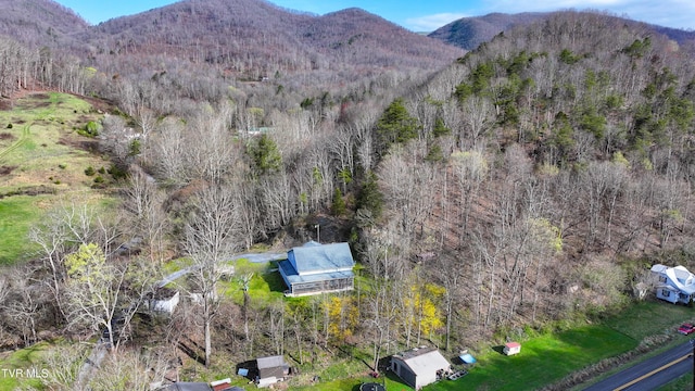 drone / aerial view with a wooded view and a mountain view