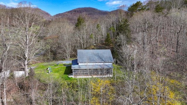 birds eye view of property featuring a forest view and a mountain view