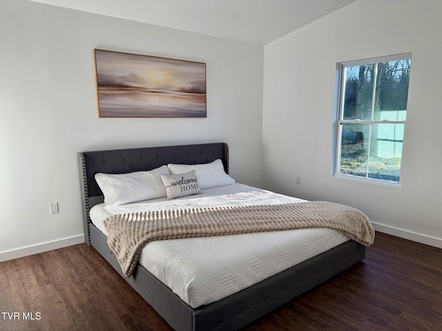 bedroom with baseboards and wood finished floors