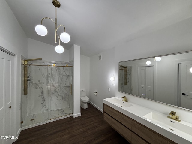 full bathroom with wood finished floors, toilet, a sink, and a marble finish shower