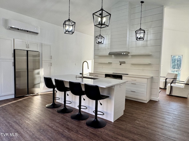 kitchen featuring a wall mounted air conditioner, light countertops, dark wood-type flooring, a sink, and freestanding refrigerator