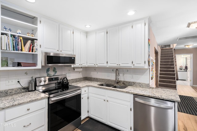 166 Lonesome Dove Ln, Elizabethton, TN 37643 - kitchen featuring white cabinets, open shelves, a sink, appliances with stainless steel finishes, and decorative backsplash