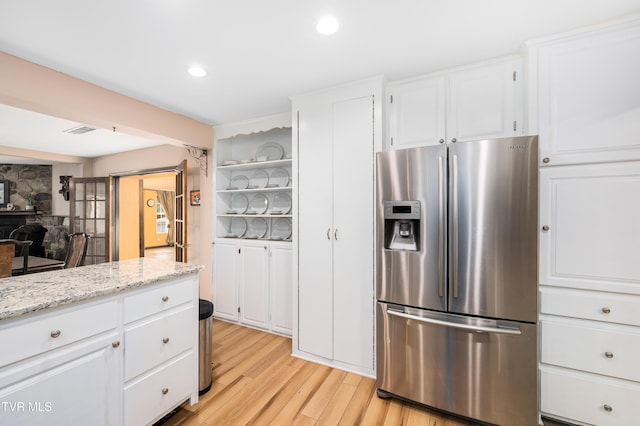 166 Lonesome Dove Ln, Elizabethton, TN 37643 - kitchen with light wood-style floors, light stone countertops, open shelves, white cabinets, and stainless steel refrigerator with ice dispenser
