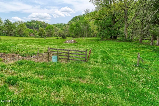 exterior space with a wooded view, a rural view, and fence