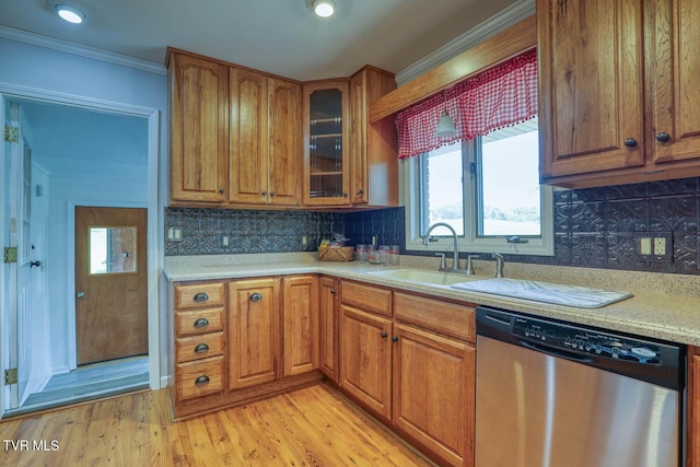 kitchen featuring a sink, stainless steel dishwasher, light wood finished floors, and brown cabinets