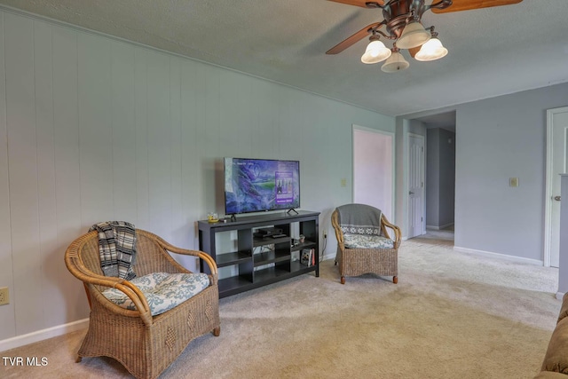 sitting room with baseboards, a ceiling fan, and carpet flooring
