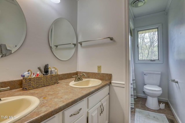 full bath with toilet, crown molding, double vanity, and a sink