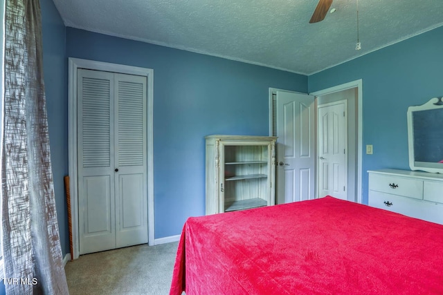carpeted bedroom featuring a textured ceiling, ceiling fan, a closet, and baseboards