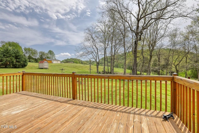 wooden deck featuring a storage unit, a yard, and an outdoor structure