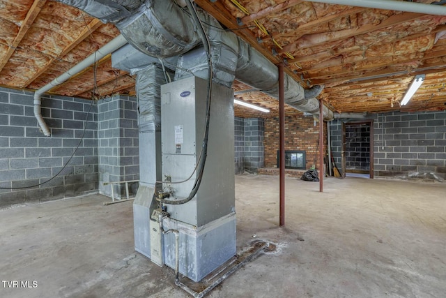 unfinished basement with heating unit and concrete block wall