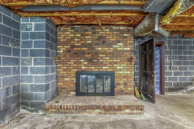 details with unfinished concrete flooring and a brick fireplace