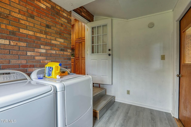 washroom with wood finished floors, washer and dryer, laundry area, and baseboards