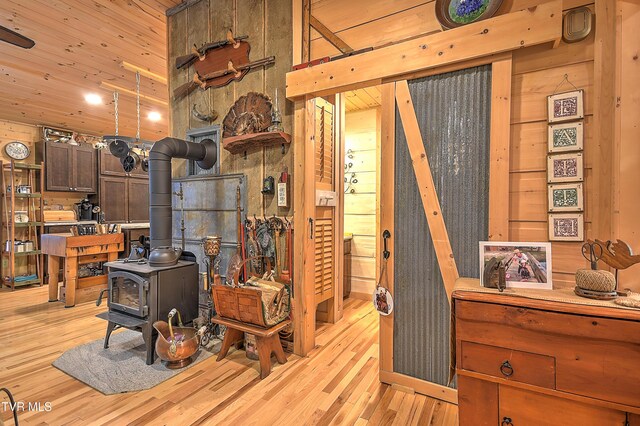 521 Baywood Dr, Piney Flats, TN 37686 - living room with a wood stove, light wood-type flooring, wooden ceiling, and wood walls