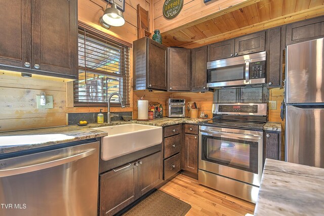 521 Baywood Dr, Piney Flats, TN 37686 - kitchen with stainless steel appliances, a sink, light wood-style flooring, light stone counters, and dark brown cabinetry