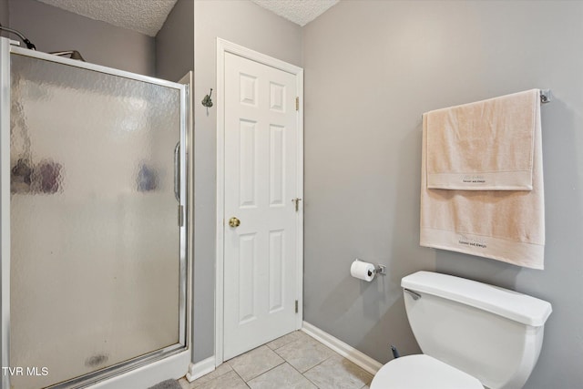 bathroom with toilet, a stall shower, tile patterned flooring, and a textured ceiling
