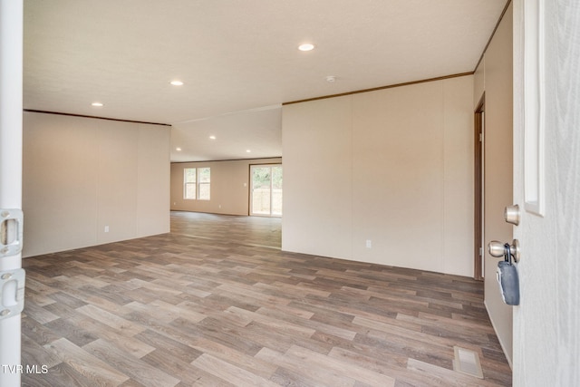 empty room with ornamental molding, visible vents, light wood-type flooring, and recessed lighting