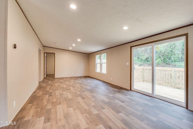 spare room with recessed lighting, light wood-type flooring, a textured ceiling, and crown molding
