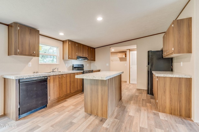 kitchen featuring dishwashing machine, under cabinet range hood, light wood-style flooring, and freestanding refrigerator
