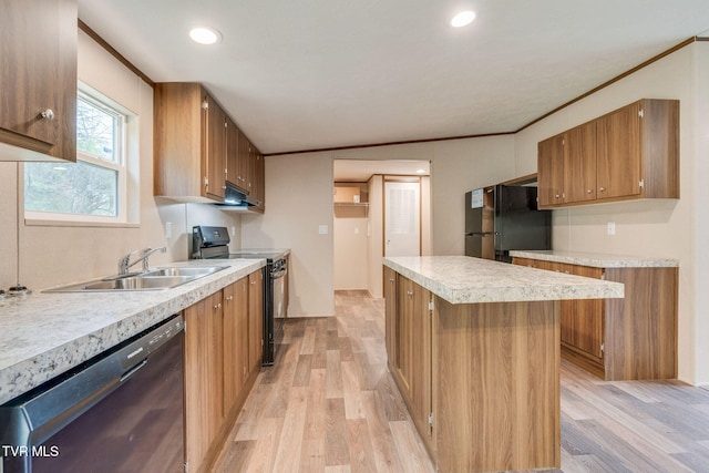 kitchen featuring a sink, light wood-style floors, under cabinet range hood, crown molding, and black appliances