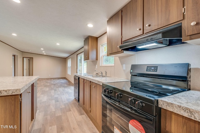 kitchen featuring under cabinet range hood, brown cabinets, a sink, and black appliances