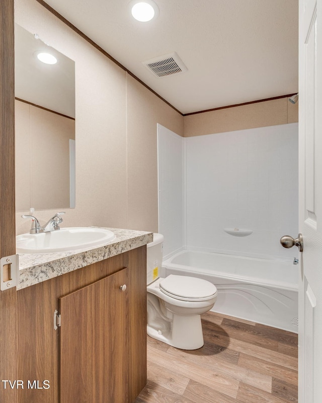 bathroom with bathing tub / shower combination, vanity, visible vents, toilet, and wood finished floors