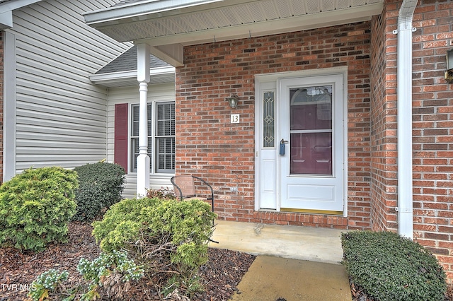view of exterior entry featuring brick siding