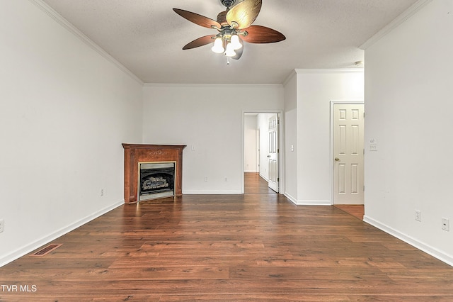 unfurnished living room featuring ceiling fan, a fireplace, dark wood-type flooring, ornamental molding, and baseboards