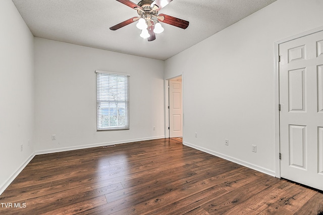 unfurnished room featuring baseboards, dark wood-style flooring, a textured ceiling, and a ceiling fan