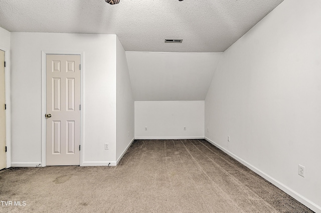 bonus room with visible vents, baseboards, a textured ceiling, carpet floors, and lofted ceiling