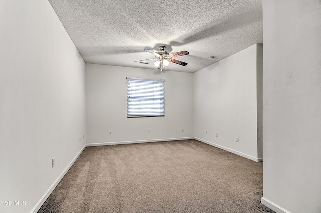 empty room featuring a textured ceiling, carpet flooring, baseboards, and a ceiling fan