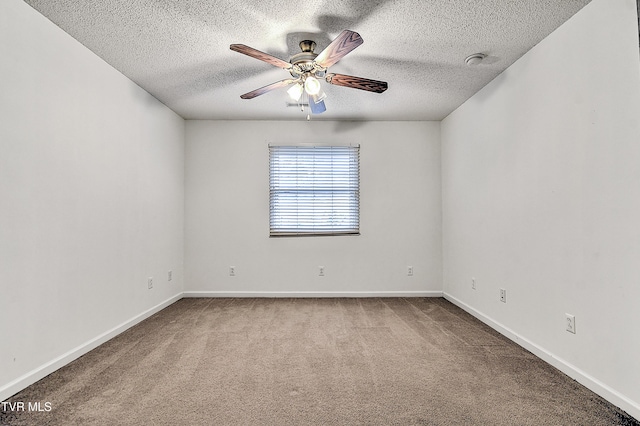 spare room featuring baseboards, a ceiling fan, carpet, and a textured ceiling