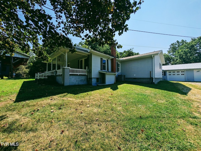 2509 Dc Caney Ridge Rd, Clintwood, VA 24228 - view of side of home featuring a garage, a yard, a porch, and an outbuilding