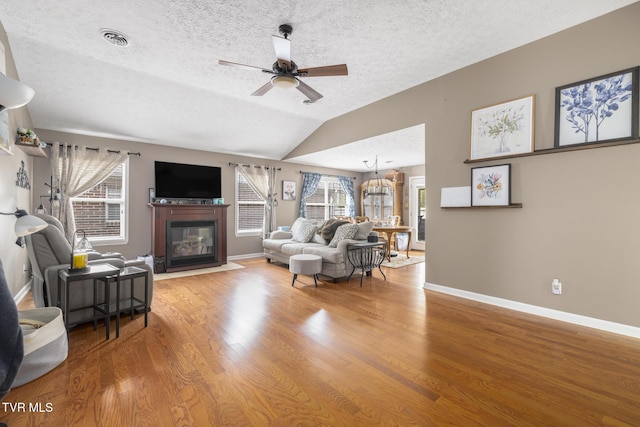 253 Crockett Dr Unit 253, Church Hill, TN 37642 - living room featuring a fireplace with flush hearth, a ceiling fan, vaulted ceiling, visible vents, and wood finished floors