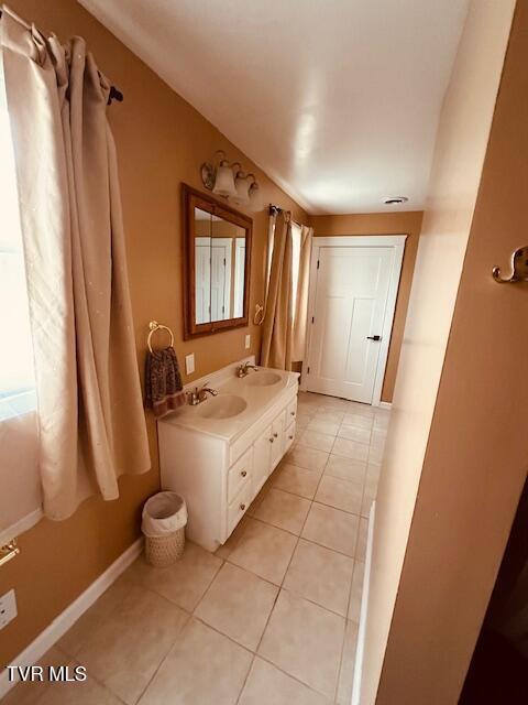 bathroom with tile patterned flooring, baseboards, and a sink