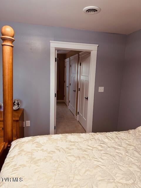 bedroom with tile patterned floors and visible vents