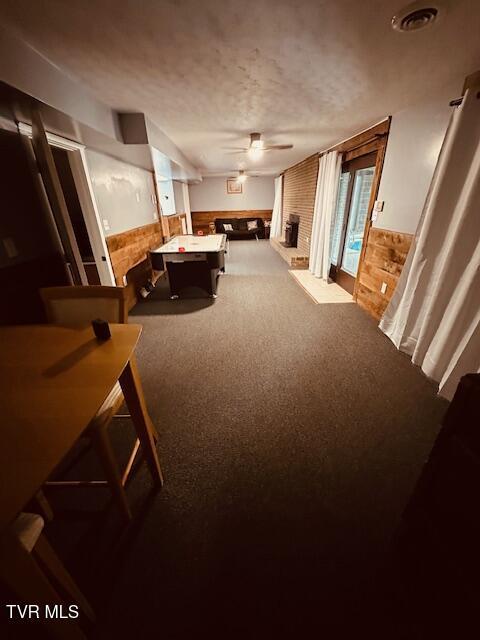 playroom featuring carpet, wainscoting, a textured ceiling, and a ceiling fan