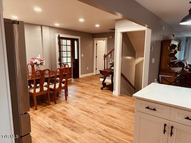 dining area with light wood-style flooring, recessed lighting, stairway, and baseboards
