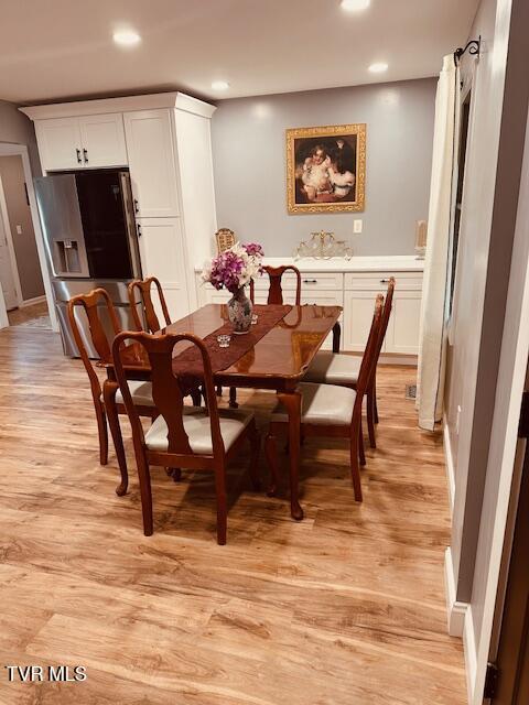 dining area with light wood-type flooring and recessed lighting