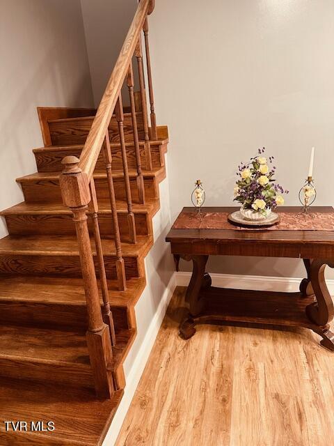 stairs featuring wood finished floors and baseboards