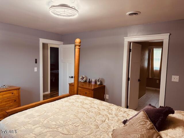 bedroom featuring tile patterned floors, baseboards, and visible vents