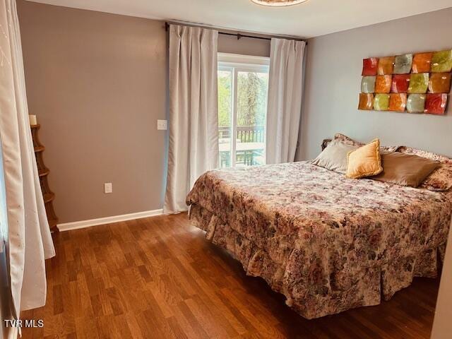 bedroom with baseboards, access to outside, and wood finished floors