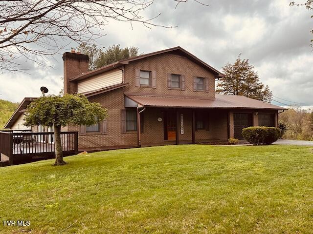 view of front of home with a chimney, a front lawn, and brick siding