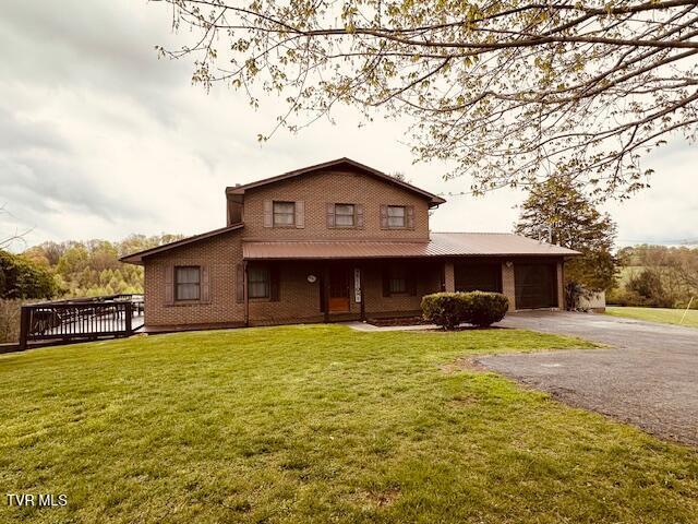 view of front of property with aphalt driveway, a garage, and a front lawn