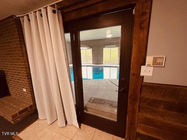 doorway with light tile patterned flooring