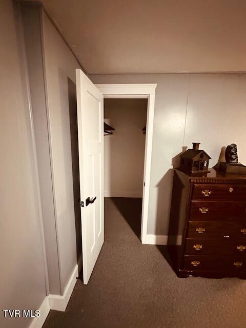 corridor with baseboards and carpet flooring