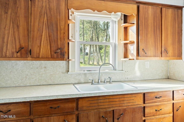 2510 Shelby St, Bristol, TN 37620 - kitchen featuring decorative backsplash, light countertops, a sink, and brown cabinets
