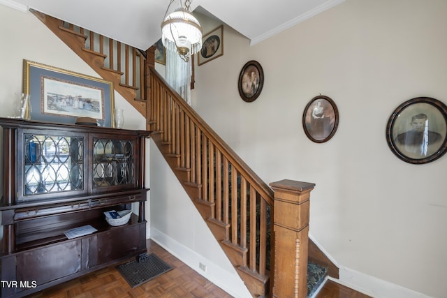 staircase featuring ornamental molding, visible vents, a chandelier, and baseboards