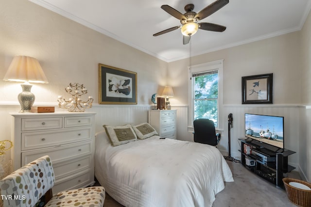 carpeted bedroom featuring ceiling fan, ornamental molding, and wainscoting